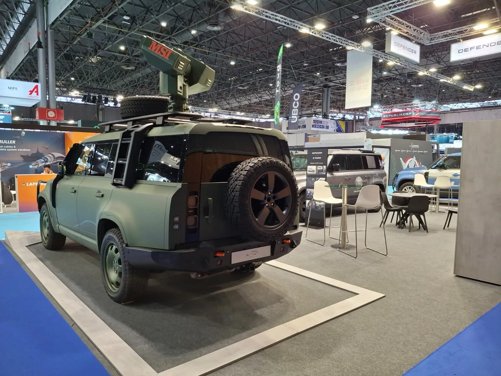 Heckansicht des grünen Defender mit fernbedienbarer Waffenstation und Reserverad am DEFENDER-Stand der Eurosatory 2026