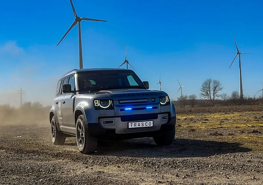 Defender 110 A-KIP® mit Blitzleuchtenpaket auf einer staubigen Piste