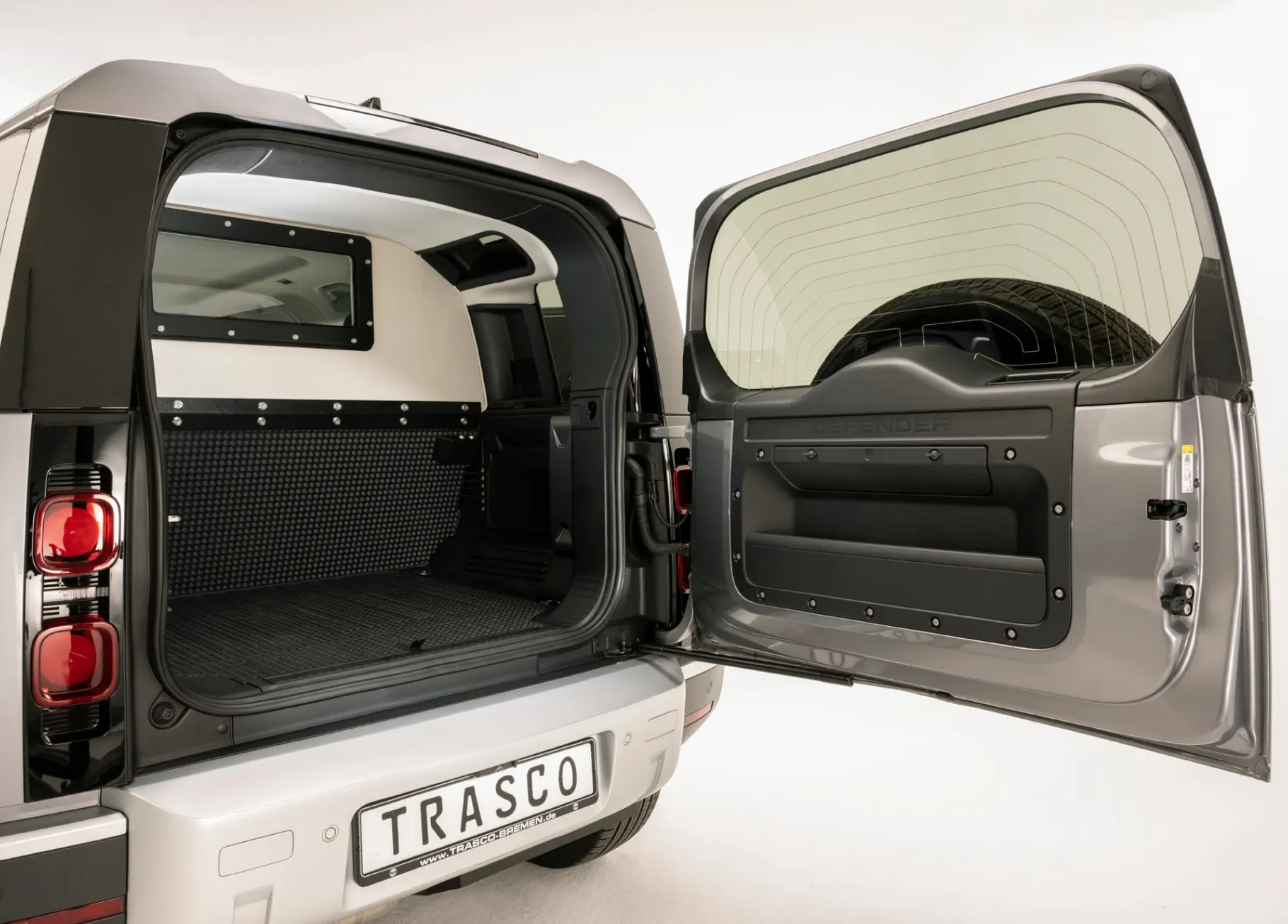 Arrière du Defender&nbsp;110, porte arrière ouverte, cloison de séparation balistique visible